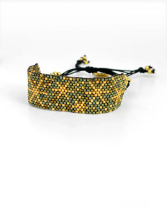 Pulsera artesanal de lujo tejida a mano con cuentas doradas y verdes estilo Erika Valencia