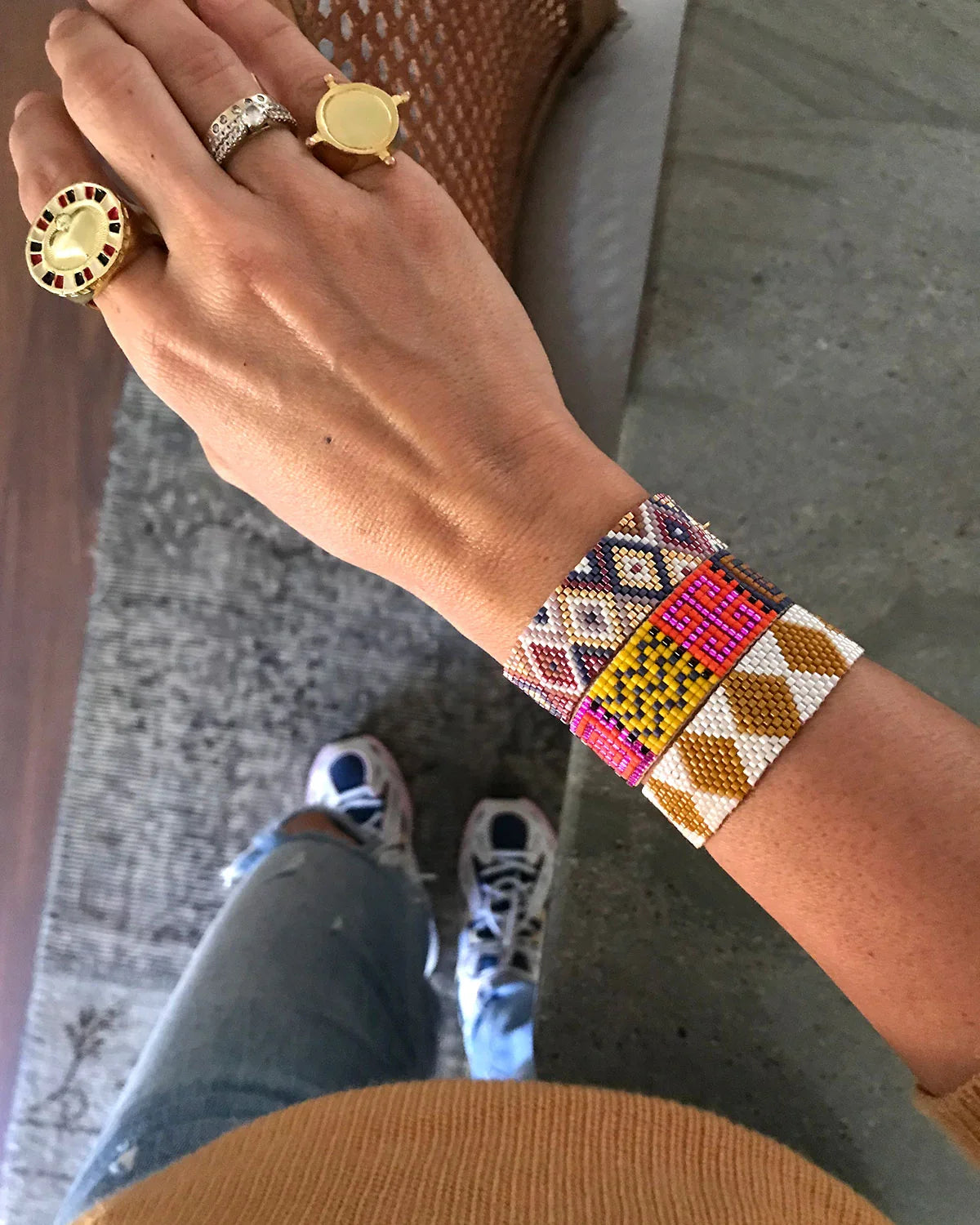 Pulsera rombos artesanal de Erika Valencia en colores blancos, marrones y vibrantes en la muñeca